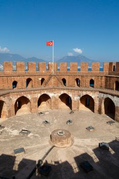 View of Alanya Red Tower in Antalya  with orenge bricks, on bright blue sky background.