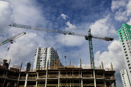 Inside place for many tall buildings under construction and cranes under a blue sky