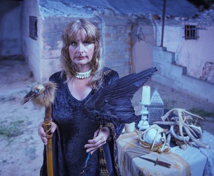 Serious female witch with altar and fetishes