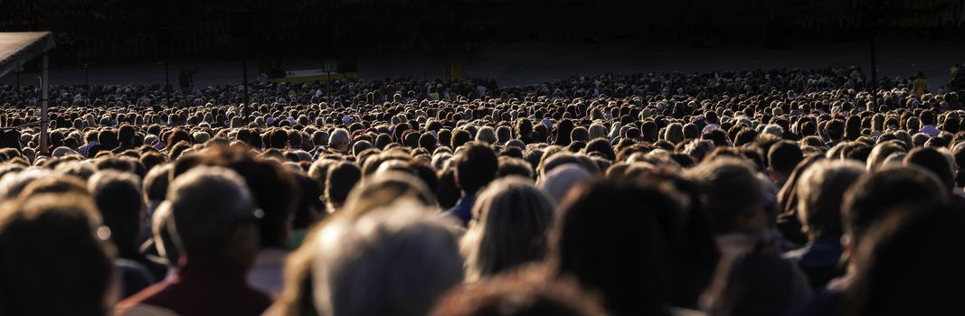 Panoramic photo of large crowd of people. Slow shutter speed motion blur.