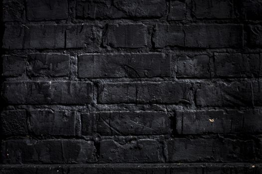 Brick wall painted with black paint.