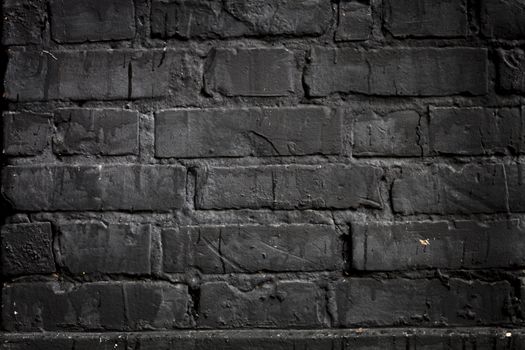 Brick wall painted with black paint.