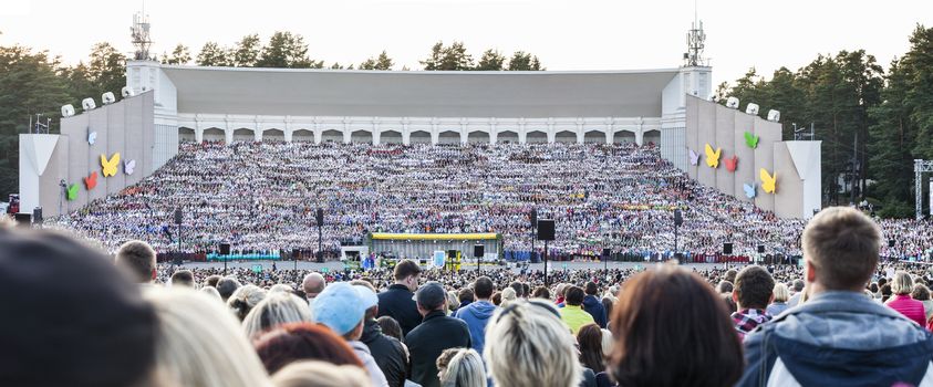 RIGA, LATVIA - July 12, 2015: The Latvian National Song and Dance Festival Grand Finale concert. View on mass choir from spectator seats.