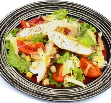 Caesar Salad with Slices of Grilled Chicken Breast, Garlic Crouton, Lettuce, Tomatoes and Grated Parmesan Cheese on Striped Plate closeup on white background