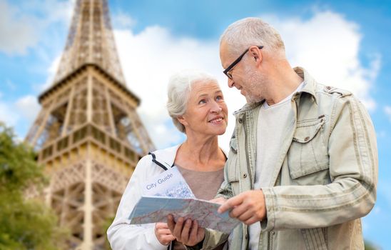 family, age, tourism, travel and people concept - senior couple with map and city guide over eiffel tower and blue sky background