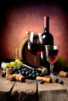 Red wine with grape and wooden cask on a wooden table