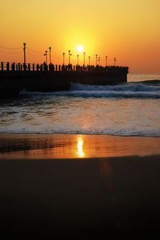 a Beatiful sunset over the pier of durban reflecting on ocean water