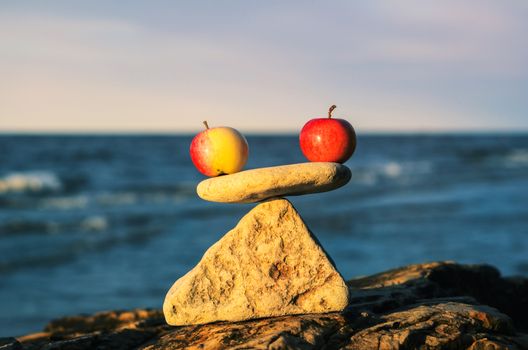 Two apples in balance on the top of stone