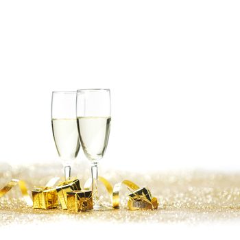 Champagne glasses and gifts on glitters with white copy space