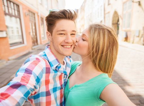 travel, vacation, technology and friendship concept - smiling couple with smartphone in city