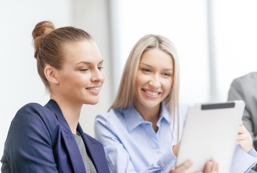 business, technology and office concept - smiling businesswomen with tablet pc computers having discussion in office