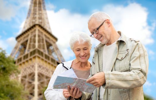 family, age, tourism, travel and people concept - senior couple with map and city guide over eiffel tower and blue sky background