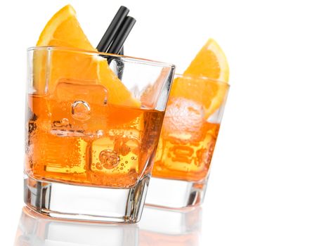 detail of glasses of spritz aperitif aperol cocktail with orange slices and ice cubes on white background