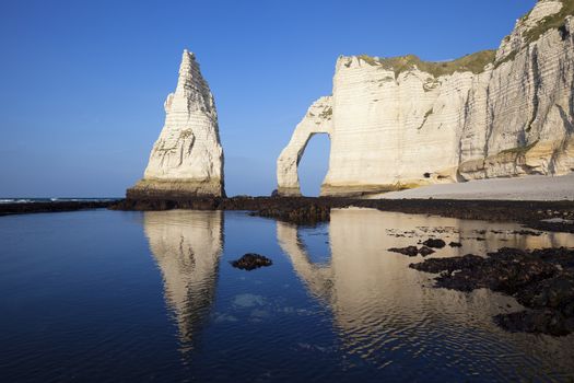 Etretat Aval cliff, rocks and natural arch landmark and blue ocean. Normandy, France, Europe.