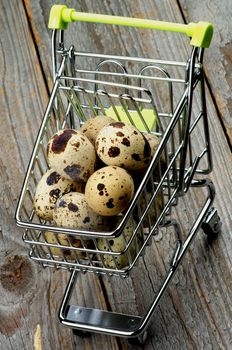 Perfect Raw Quail Eggs in Trolley closeup on Rustic Wooden background