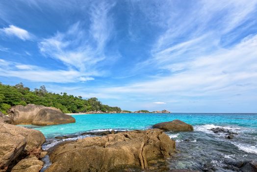 Beautiful landscape of blue sky sea and white waves on beach near the rocks during summer at Koh Miang island in Mu Ko Similan National Park, Phang Nga province, Thailand