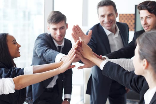 Happy business team making high five with their hands in the office