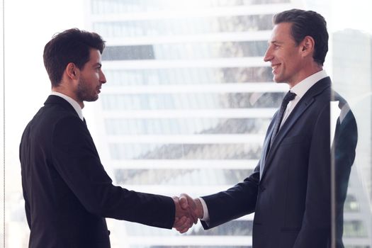 Business people shaking hands, finishing up a meeting in office