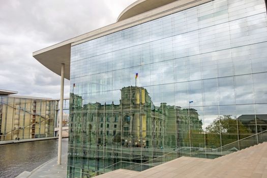 Berlin, Germany - October 28, 2013: Reichstag in Berlin mirroring in Marie-Elisabeth-Luders-Haus (parliament building).