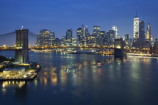 New York City Manhattan midtown at dusk with Brooklyn Bridge.