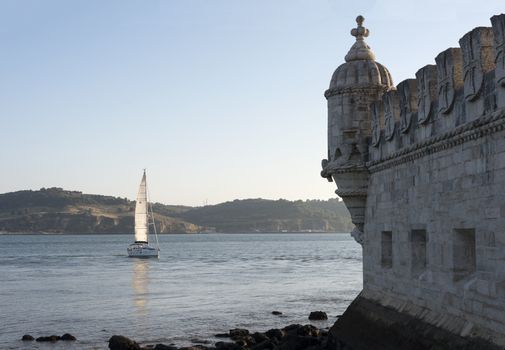 schip is sailing on the Tagus river in front of the Belem tower in Lisbon Portugal