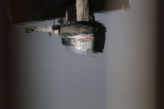 Reflections of outboard motor in lake morning light