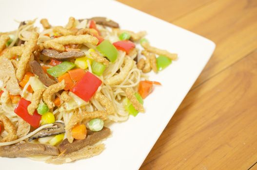 Colorful long life noodle fried with cauliflower, carrots, mushroom, red and green bell pepper and vegan protein dry vegetarian food.