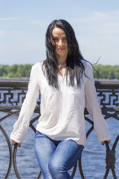 Standing young Caucasian woman on river background