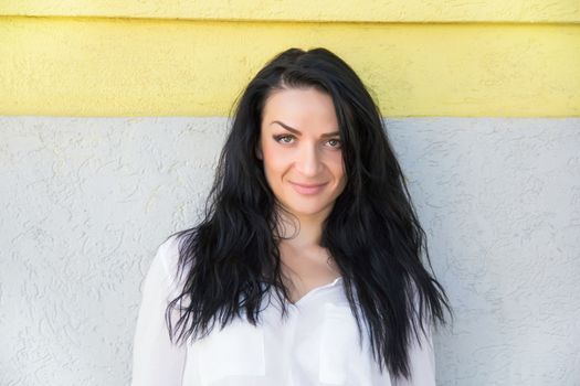 European brunette on background white yellow wall