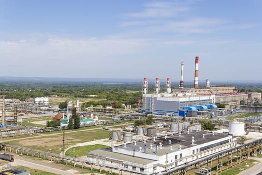 Industrial landscape of refinery at summer day through smoke