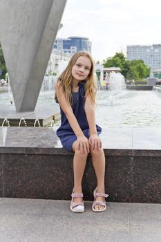 Cute girl with blond hair on fountain background