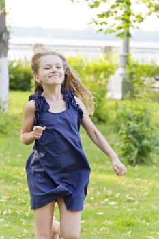 Girl is running in park on green grass