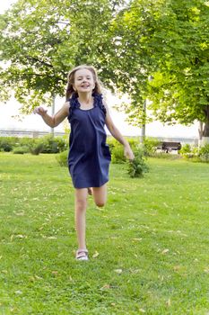Girl is running in park on green grass