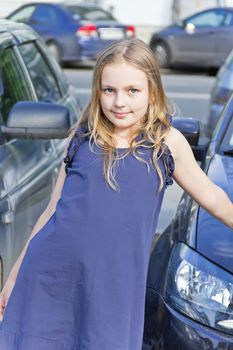 Cute girl with blond hair in blue dress