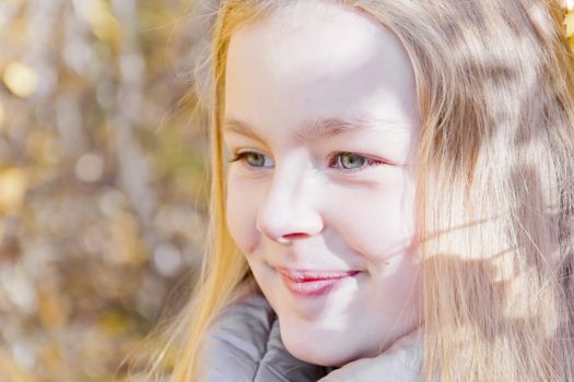 Autumn portrait of blond girl in sunlight