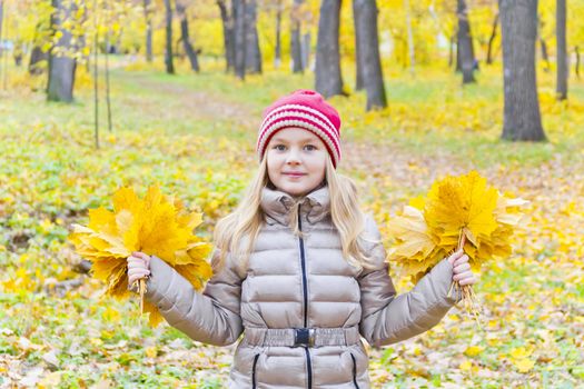 Playing girl with two bouquets from sheets in park