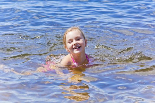 Swimming smiling cute girl seven years old