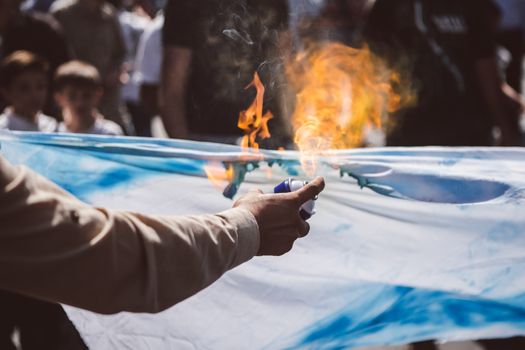 JORDAN, Ammam : A man burns an Israeli flag while around 5,000 people protest against Israeli violations against Palestinians  in the center of Ammam, capital city in Jordan on October 16, 2015. Demonstrators ask for the end of 1994 Israel-Palestine peace treaty. Since October 1st, 2015, tensions in border between Israel and the Gaza strip get higher. Seven Israelis have been killed in more than two dozen attacks by Palestinians this month, mostly in Jerusalem, and about 70 have been wounded. 