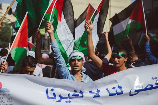 JORDAN, Ammam : A man raises a Palestinian flag while around 5,000 people protest against Israeli violations against Palestinians  in the center of Ammam, capital city in Jordan on October 16, 2015. Demonstrators ask for the end of 1994 Israel-Palestine peace treaty. Since October 1st, 2015, tensions in border between Israel and the Gaza strip get higher. Seven Israelis have been killed in more than two dozen attacks by Palestinians this month, mostly in Jerusalem, and about 70 have been wounded. 