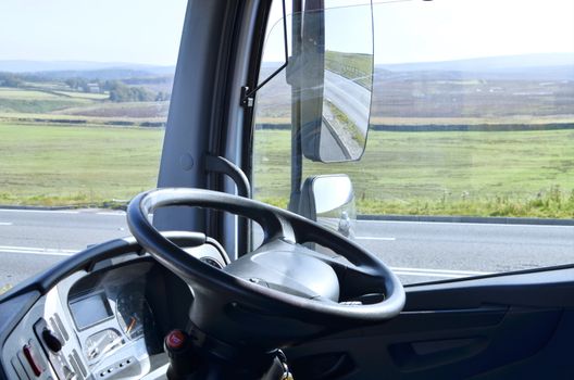 Steering wheel in lorry  cab, view of  dashboard and side mirrors

