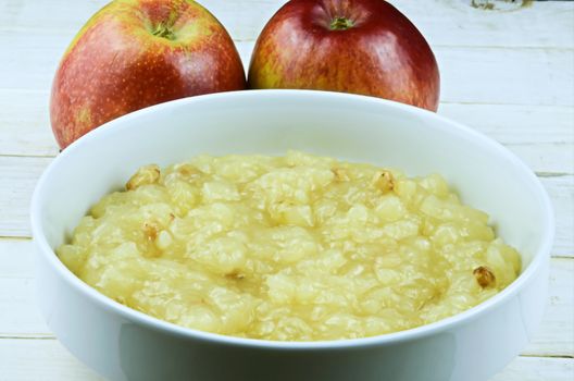 Fresh AppleSauce against background with two apple
