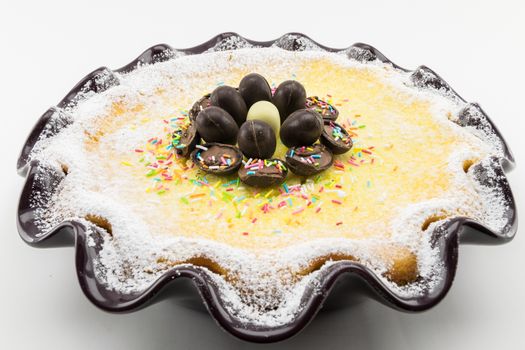 Easter cake with ricotta and chocolate decorated with chocolate eggs and powdered sugar