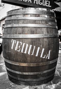 Wooden barrel with iron rings with the word "tequila" in white.