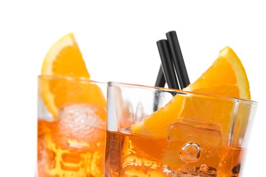 detail of two glasses of spritz aperitif aperol cocktail with orange slices and ice cubes on white background