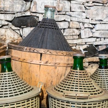 Demijohns of wine in a stone cellar.