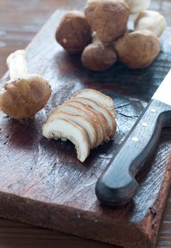 Raw mushrooms on a wooden cutting board ready to be sliced