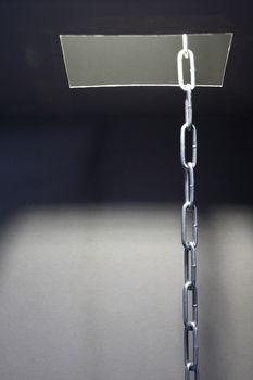 Escape concept. Metal chain inside hatch in ceiling