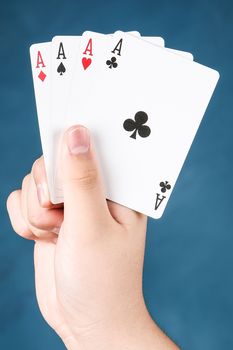 A winning poker in hand of four aces playing cards suits on blue chalkboard
