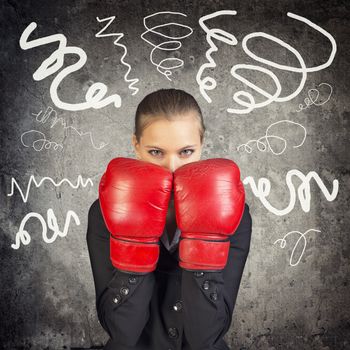 Businesslady in boxing gloves on abstract background