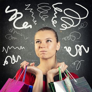 Young woman with shopping bags on abstract background